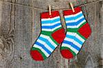 Colorful socks hanging on the clothesline on old wooden background