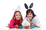 Happy kids with the easter bunny and colorful eggs - wearing bunny ears
