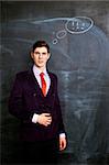 Portrait of thoughtful businessman witn chalkboard  on background