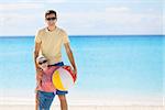 family of two holding beach ball and enjoying vacation together at summer