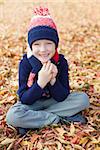 cute smiling boy enjoying autumn weather at the park