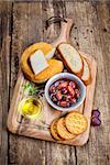 Greek olives, cheese and extra virgin Olive oil  on a wooden board