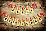 Merry Christmas lettering with clothes-peg in shape of train on old wooden background