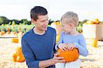 family of two having fun at pumpkin patch together