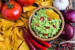 Guacamole in Wooden Bowl with Tortilla Chips and Ingredients