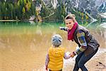 Did you see that? A mother in hiking gear smiling and pointing out to the lake. Seen from behind, her daughter is looking out at the lake and holding her mother's hand. Fall colours.