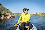 senior male paddling a decked expedition canoe on Horsetooth Reservoir, Fort Collins, Colorado, springtime scenery