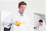 Scientists working attentively with test tube and microscope in laboratory