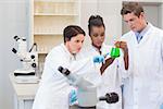 Scientists looking at green precipitate in the laboratory