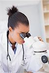 Scientist looking in microscope in laboratory