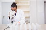 Scientist looking through a microscope in laboratory