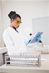 Concentrated scientist working with tablet in laboratory