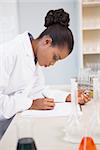 Concentrated scientist taking notes in laboratory