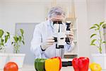 Food scientist looking through a microscope in laboratory