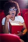 Surprised young woman watching a 3d film at the cinema