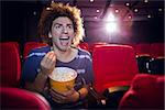 Happy young man watching a film at the cinema