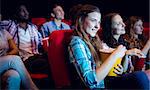 Young friends watching a film at the cinema