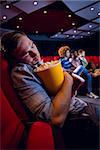 Young man sleeping at the cinema