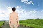 Asian businesswoman against road leading out to the horizon