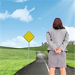 Businesswoman against road leading out to the horizon