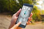 hand holding smartphone against tarmac curved country road in forest