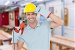 Handsome architect holding drill machine against workshop