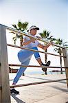 Senior woman stretching by beach