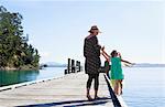 Mid adult woman and daughters playing on pier, New Zealand