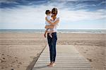 Mid adult woman and toddler daughter on beach, Castelldefels, Catalonia, Spain