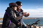 Cyclist couple using smartphone, Connemara, Ireland