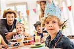 Portrait of boy wearing party hat at birthday party