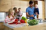 Girl with family preparing fresh vegetables in kitchen