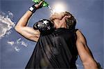 Low angle view of mid adult male boxer drinking bottled water