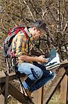 Hiker reading map on wooden handrail, Montseny, Barcelona, Catalonia, Spain