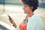 Young woman listening to smartphone music