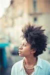 Portrait of beautiful young woman gazing in city