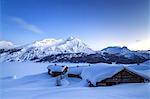 The blue hour leaving its place to the night over some scattered huts in Spluga by the Maloja Pass, Graubunden, Swiss Alps, Switzerland, Europe