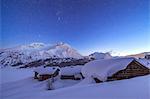 A starry night covering the Spluga huts submerged in snow near the Maloja Pass, Graubunden, Swiss Alps, Switzerland, Europe