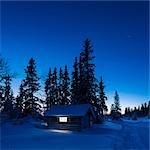 Illuminated log house at night