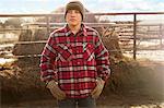 Portrait of boy with hands on hips in dairy farm yard