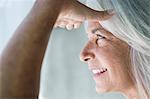 Close up of mature woman with hand shielding eyes