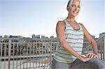Portrait of mature woman doing warm up exercises on city balcony