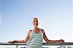 Portrait of mature woman in sports clothing leaning against city balcony