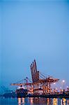 View of container ship and gantry cranes in harbor at night, Tacoma, Washington, USA