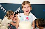 Children on birthday party serving cake, Munich, Bavaria, Germany