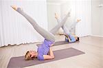 Women doing Pilates exercises, stretching legs