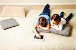 Children using tablet computer at home, Munich, Bavaria, Germany