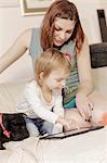 Mother and daughter using digital tablet together