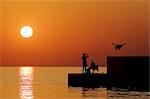 People on the waterfront at sunset, Adriatic Sea, Croatia