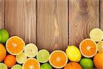 Citrus fruits. Oranges, limes and lemons. Top view over wooden table background with copy space